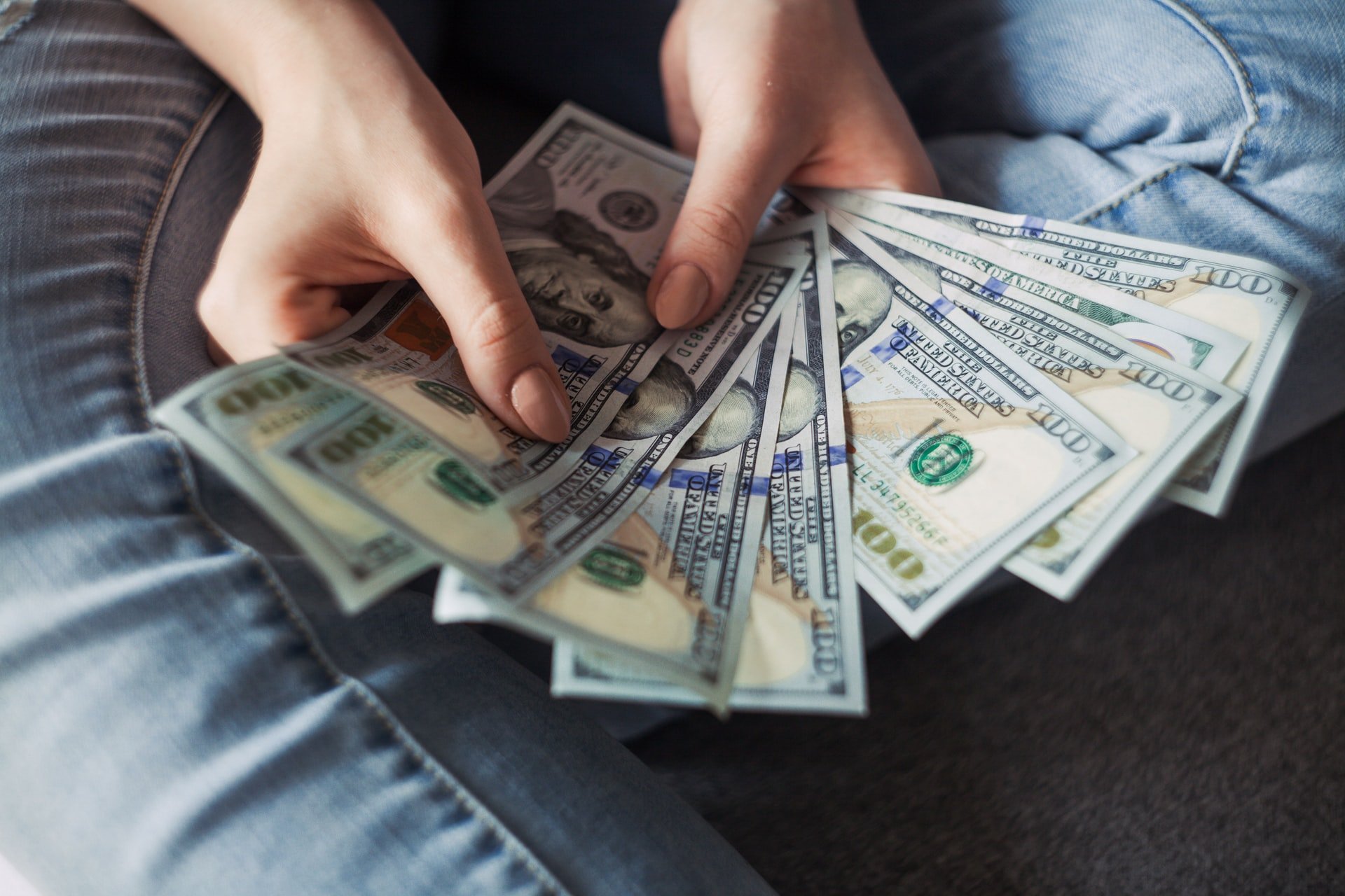 Someone counting a fan of US dollars.